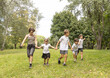 © malyutinaanna - Children Joyfully Playing Together in a Sunny Park During a Delightful Summer Afternoon Filled With Laughter and Friendship