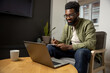 © zinkevych - African american young man working on a laptop