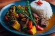 © Ixam - Delicious plate of curry with rice, broccoli, carrots, and herbs on a dark blue plate