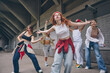 © master1305 - Redhead female dancer moving forward with confidence during street choreography. Concept of youth culture, dance and music, lifestyle expression, fashion branding and social media promotion.