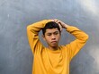 © Wahjoekris - An authentic portrait of a Southeast Asian Indonesian teenager in a yellow t-shirt, his cheerful and hopeful expression capturing an exotic and vibrant energy