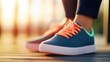 © tashechka - Brightly colored athletic shoes on a sunlit wooden surface during evening