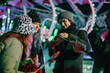© qunica.com - Joyful friends sharing cotton candy while visiting a brightly lit winter market. Vibrant colors and an excited atmosphere depict the spirit of togetherness and celebration during the festive season.