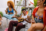 Brazilian friends playing cavaquinho and drinking together at summer gathering