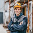 © Tondo - Smiling young construction worker wearing helmet outdoors