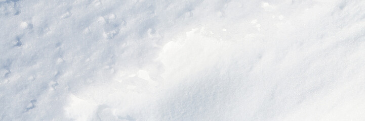 Wall Mural - Beautiful winter background with snowy ground. Natural snow texture. Wind sculpted patterns on snow surface. Wide panoramic texture for background and design.