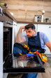 © Marko - Technician troubleshooting kitchen oven in modern home