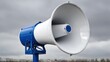 © Nanda - A large, outdoor loudspeaker against a cloudy sky.