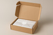 © Andika - Open cardboard shipping box with a product wrapped in tissue paper and a blank sticker