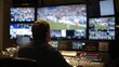 © mila103 - A technician operates broadcast equipment while monitoring various screens displaying a sports game. The control room is busy, ensuring live coverage goes smoothly.