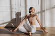 © anatoliycherkas - Young woman practicing yoga spinal twist pose at home