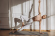 © anatoliycherkas - Woman practicing yoga side plank pose at home