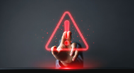 A hand touching a red glowing exclamation point inside of a triangle on a dark gray background