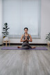 © Kritdanai - Woman Practicing Yoga in Bright Room