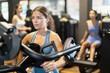 © JackF - Sportive young girl training on chest press machine in fitness hall during full-body workout