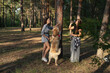© leroy - Two girls are walking with retriever dog in the pine forest.