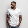 © Surachetsh - A Black man in a plain white t shirt stands against a neutral background. The blank shirt is ideal for clothing mockup and fashion display.