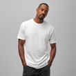 © Surachetsh - A Black man in a plain white t shirt stands against a neutral background. The blank shirt is ideal for clothing mockup and fashion display.