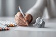 © Jane_S - Close-up of child drawing with elephant figurine and colorful pencils