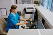 © AnnaStills - Caucasian middle aged woman working at medical reception desk typing on computer keyboard, sitting in modern healthcare facility, using office equipment and telephone