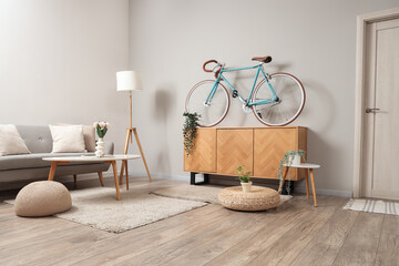 Poster - interior of light living room with bicycle, commode and sofa