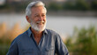 © Nataliya - A senior man smiles outdoors, the joyful scene illuminated by gentle light. Man, senior, with copy space