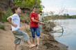 © leroy - Grandfather and father is teaching a grandson fishing on the river beach.