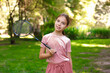 © New Africa - Portrait of smiling little girl with badminton racket in park