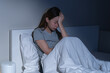 © KMPZZZ - Sad worried and stressed, depressed asian young woman, girl suffering in bed from insomnia problem, awake at night, hand covering face from trouble disturbed loud noise, unable sleep. Restless people.