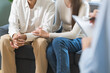 © KMPZZZ - Psychology, depression asian young couple love woman and male patient consulting problem mental health with psychologist, psychiatrist at clinic together, wife encouraging husband, therapy health care