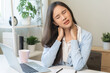 © KMPZZZ - Body muscles stiff problem, ache asian young woman, girl pain neck while sitting work on chair at home, holding massaging rubbing, hurt or sore, Healthcare people, office syndrome.