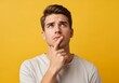 © tebu - Pensive Young Man Contemplating, Studio Shot Against Vibrant Yellow Background.