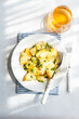© RooM The Agency - Overhead view of a bowl of traditional Greek potato salad (Patatosalata) on a table with cutlery, napkin and a glass of wine