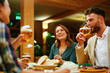 © djile - Happy friends toasting with beer glasses at restaurant dinner