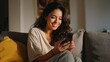 © Johannes - happy 20s young woman watching social media videos looking at smartphone relaxing on couch smiling hispanic girl enjoying using online mobile apps doing online shopping on cell phone at home no logos