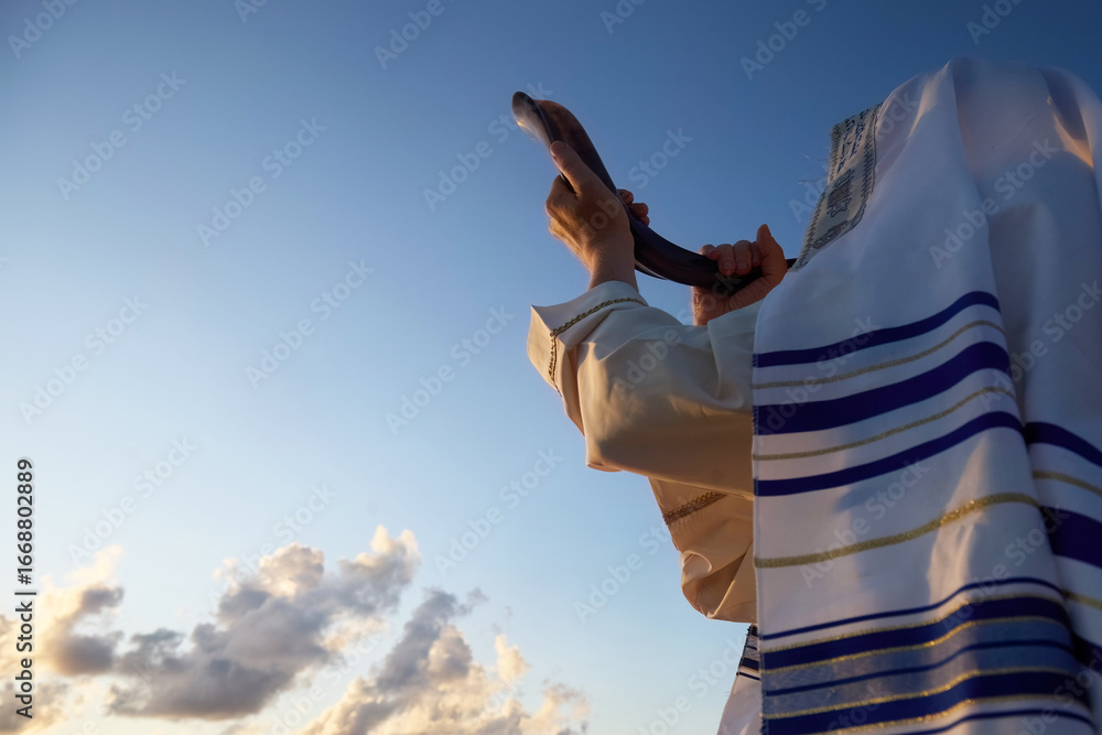 Jewish man blowing the Shofar horn of Rosh Hashanah - New Year. Shofar at Sunset