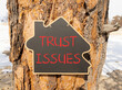 © Dzmitry - Trust issues symbol. Concept word Trust issues on beautiful black blackboard. Beautiful old pine tree background. Black blackboard. Business trust issues concept. Copy space.