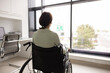 © fizkes - Unhappy depressed woman with disability sitting in wheelchair at window