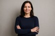 © Татьяна Евдокимова - Portrait of a confident businesswoman smiling with crossed arms, showcasing professionalism and success against a gray background