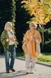 © dsheremeta - Two senior women walking and talking in a park during autumn