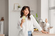 © Pixel-Shot - Young Asian woman with citrus infused water in kitchen