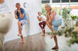 © JackF - Group of happy mature sports women and man in activewear exercising dynamic dancing movemens in modern gym studio