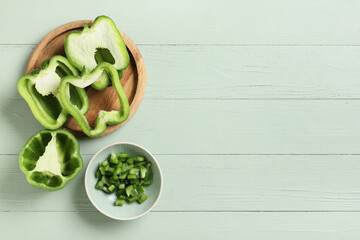 Wall Mural - plate and bowl with cut bell peppers on green wooden background
