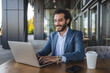 © Miljan Živković - middle eastern businessman working on laptop in outdoor cafe setting