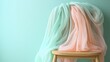 © melvilsky - Pastel fabrics draped over a wooden chair, creating a soft, elegant scene.