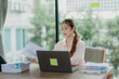 © Wanchai - Professional Asian woman committed to her work, surrounded by office documents and computer.