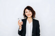© dadakko - Japanese woman holding smartphone. Smiling businessperson portrait