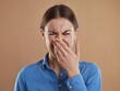 © Asadur - Young Woman Feeling Disgusting Smell, Hands Covering Nose