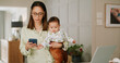 © peopleimages.com - Phone, woman and baby in home for communication, networking or multitasking. Laptop, single mother and child for remote work, research and time management with freelancer mom in house for message