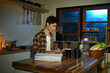 © Stella 16 - Focused man working late at night on laptop in kitchen with coffee